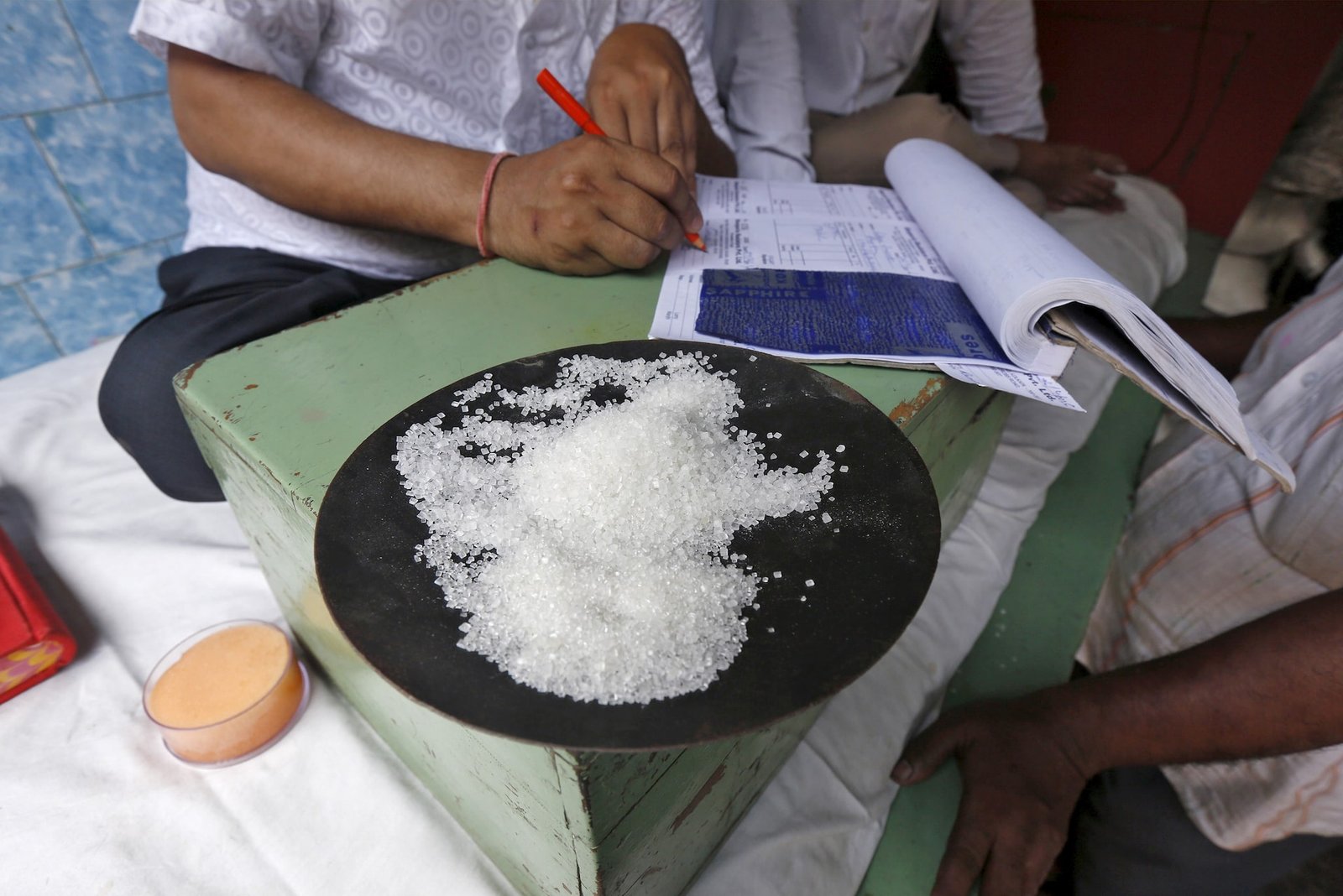 24lt7lbffnpuxnw4wrvimno5eu A sample of sugar crystals are seen on the desk of a trader at a wholesale market in Kolkata